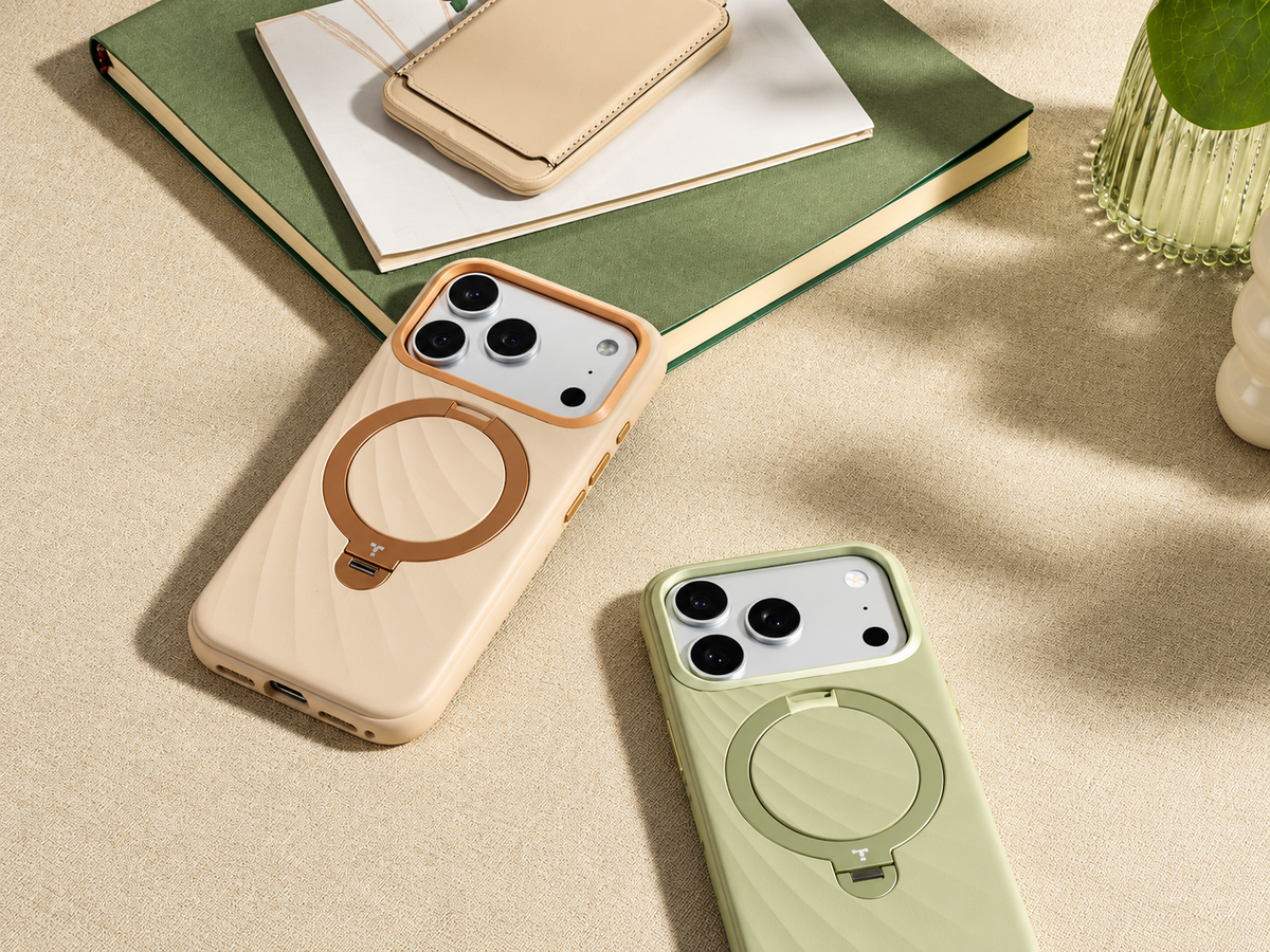 Drei iPhones in Beige, Rosa und Grün mit Silikonhüllen auf einem Schreibtisch