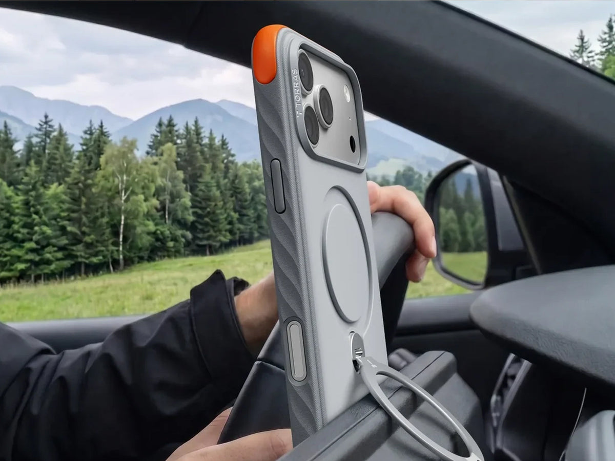 iPhone in der Auto-Halterung mit Blick auf eine Bergstraße durch die Windschutzscheibe