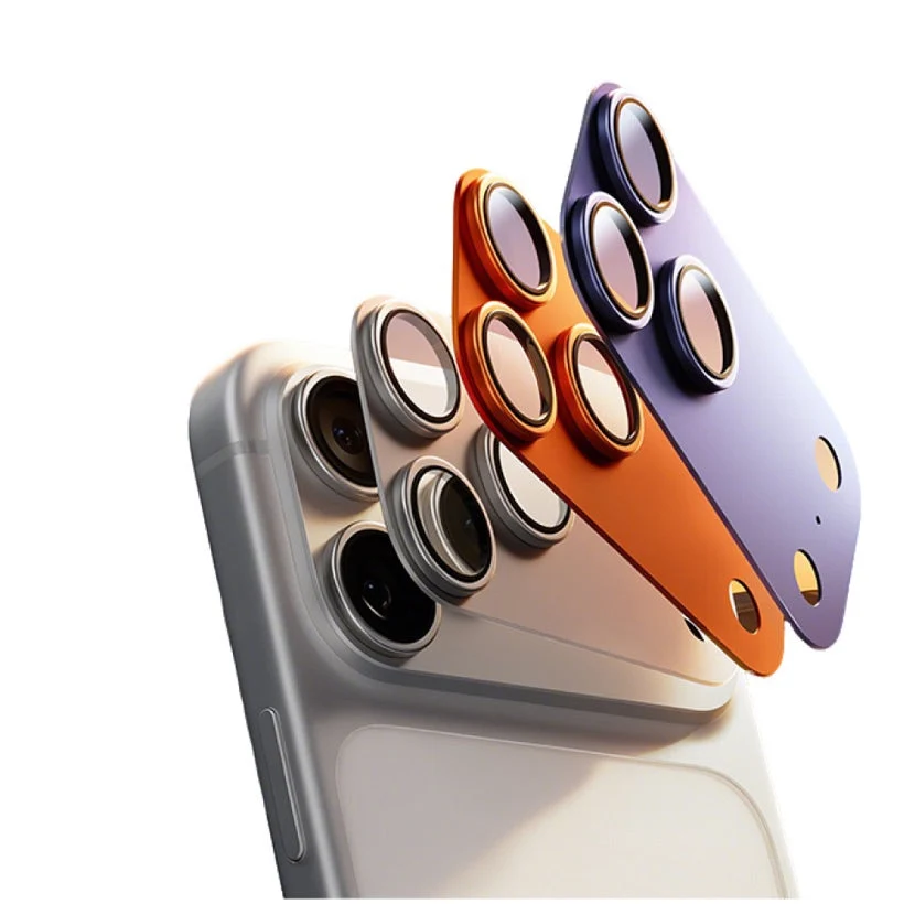 Kameraschutz-Aufsätze in Silber, Orange und Violett schweben über einem iPhone