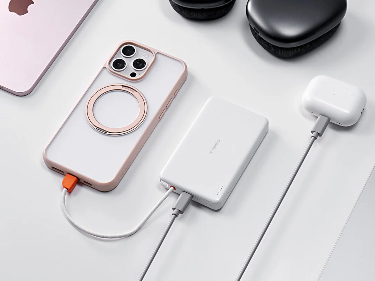 iPhone 18 Pro mit MagSafe-Ring neben Powerbank und Kopfhörern auf weißem Tisch